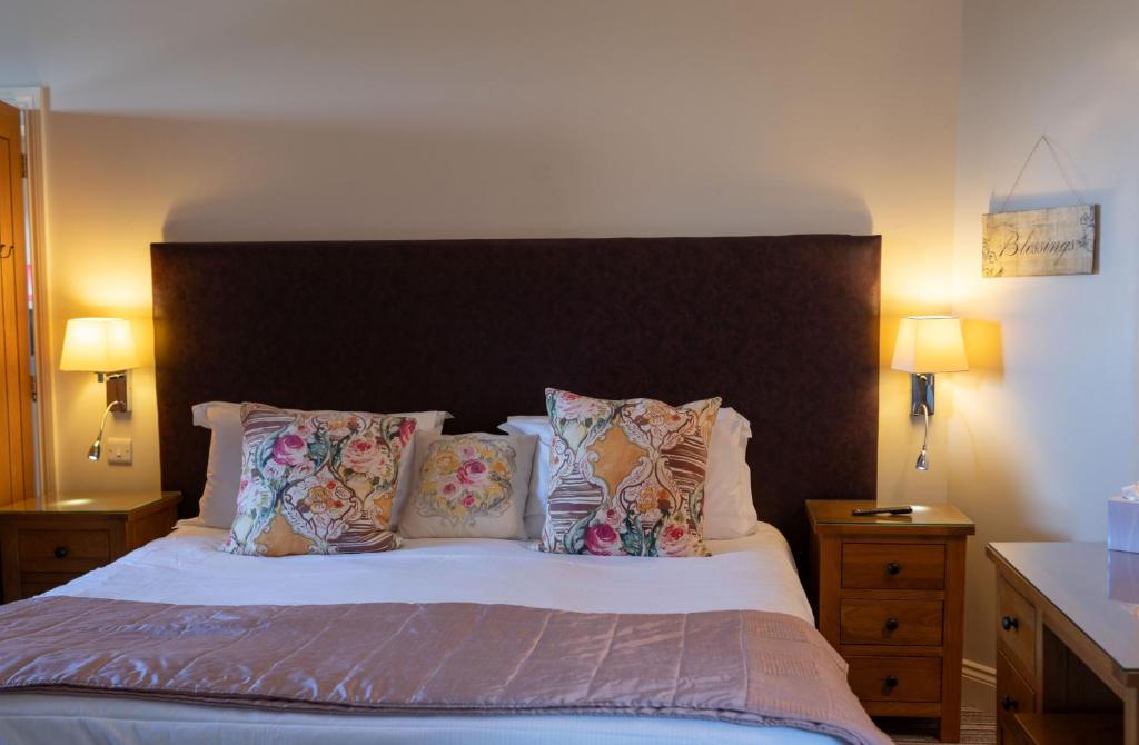 a bedroom with a large bed with pillows at Oak Cottage, Castle Carrock, Nr Carlisle in Castle Carrock