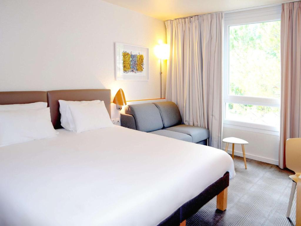 Postel nebo postele na pokoji v ubytování Novotel Grenoble Nord Voreppe