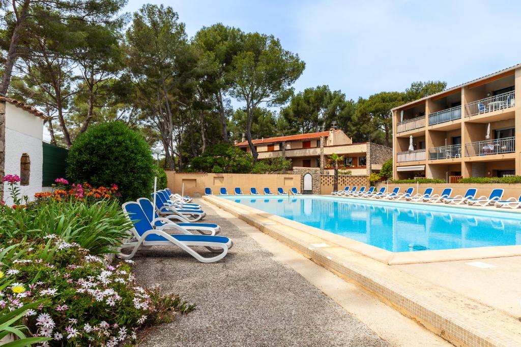 - une piscine avec des chaises longues à côté d'un complexe dans l'établissement Sanary soleil et douceur 3, à Sanary-sur-Mer