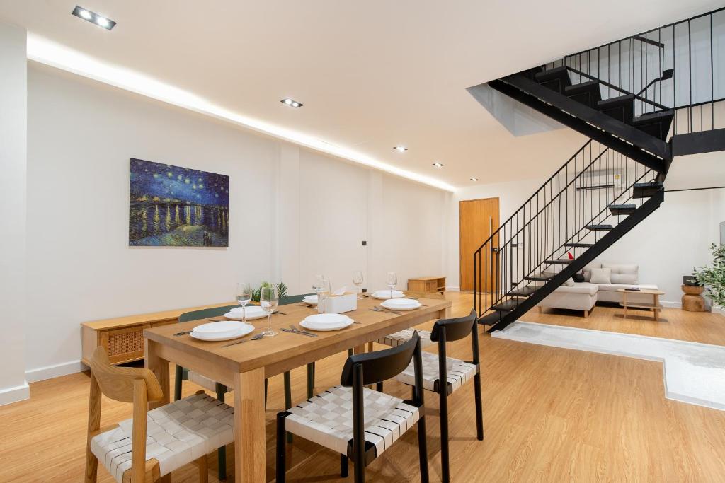 a dining room with a table and chairs and a staircase at Townhouse in Khet Phayathai - Ari in Bangkok