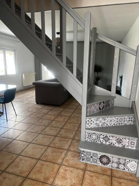 un salon avec un escalier et un canapé dans l'établissement Small house with garden, à La Celle-sous-Gouzon