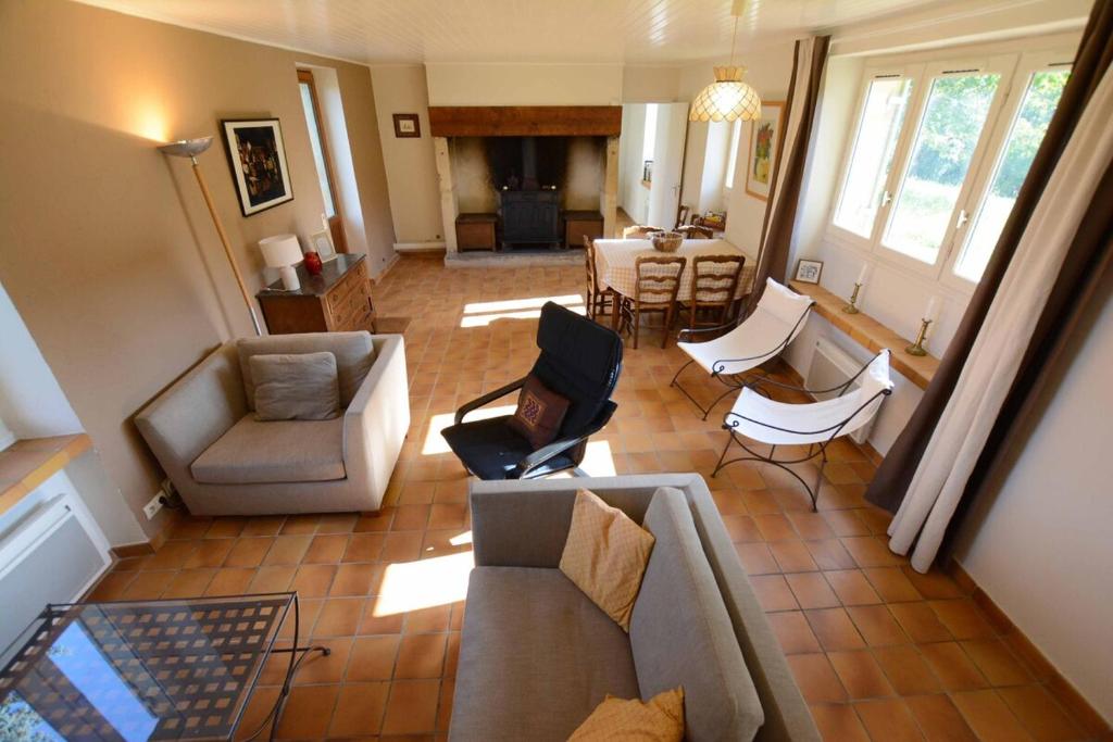 un salon avec un canapé, des chaises et une table dans l'établissement Les Bardilles-Maison de campagne-3km du centre de Sarlat, à Sarlat-la-Canéda