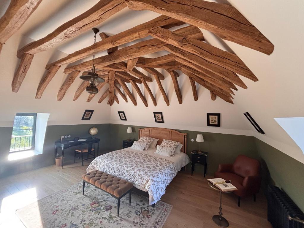 - une chambre avec un lit et des poutres apparentes dans l'établissement Le Domaine de la Haye Chambres d'Hôtes, à Saint-Christophe-du-Bois