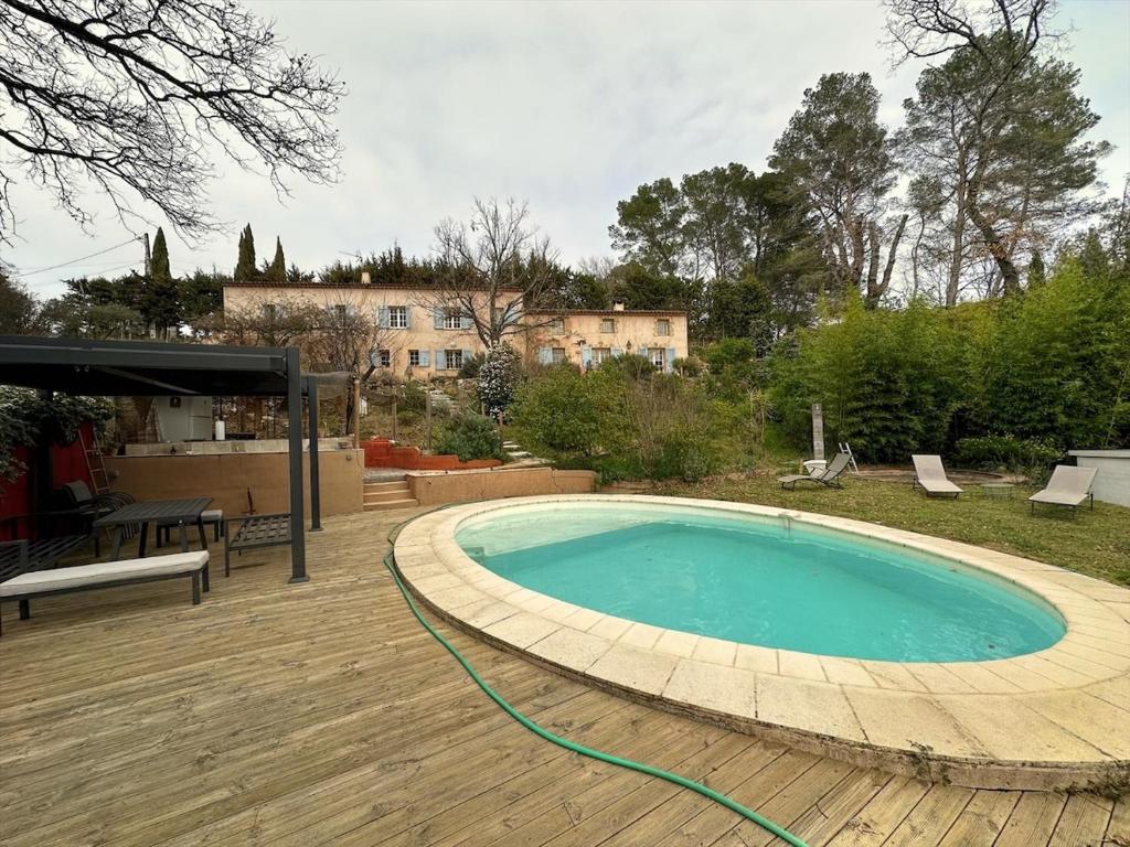 une grande piscine sur une terrasse en bois dans l'établissement Authentique mas provençal avec charme, Villecroze, à Villecroze