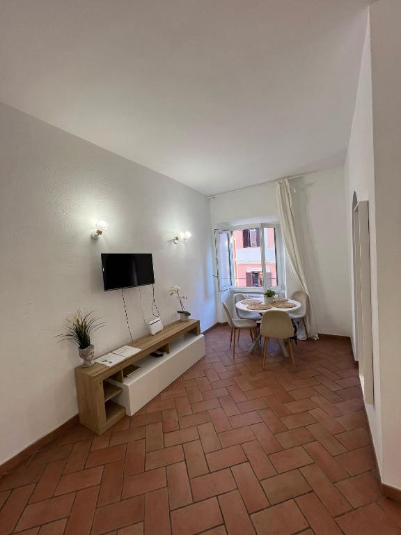 salon z telewizorem z płaskim ekranem i stołem w obiekcie Colosseum 20 apartment w Rzymie
