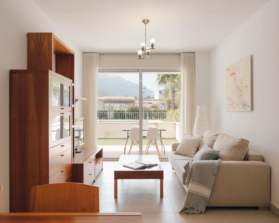 a living room with a couch and a table at Marina Real I - Casa Areca in Denia