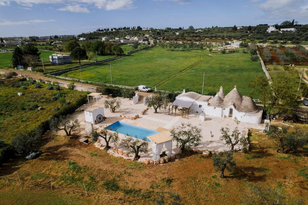 une cuisine avec des armoires blanches et un réfrigérateur blanc dans l'établissement Trullo La Dama Forestiera, à Alberobello