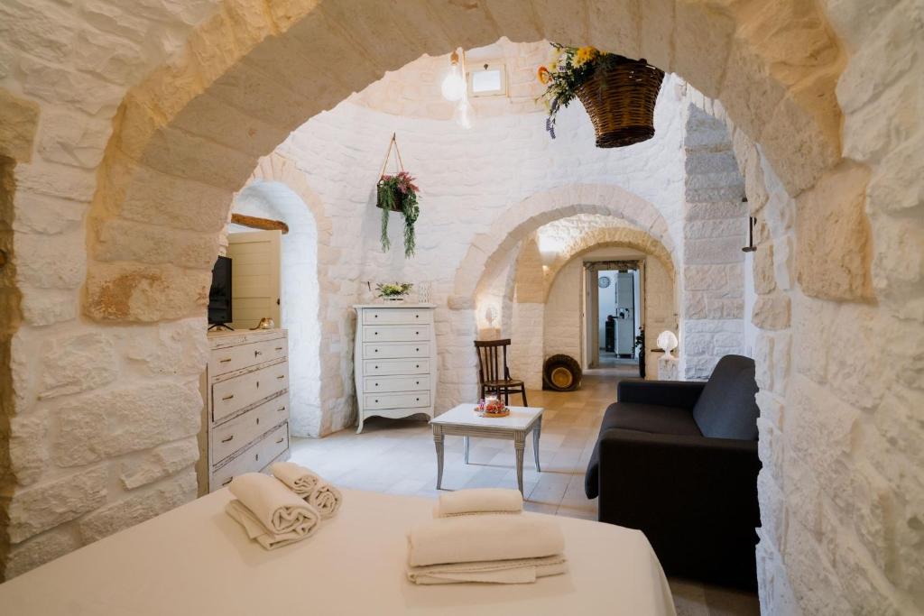 - une chambre avec un lit et une commode avec une télévision dans l'établissement Trullo La Dama Forestiera, à Alberobello
