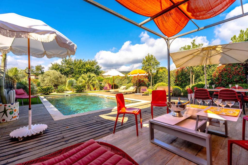 un patio avec une table et des chaises et une piscine dans l'établissement Villa Les Mures l Pool & Garden l Shellter Rentals, à Grimaud