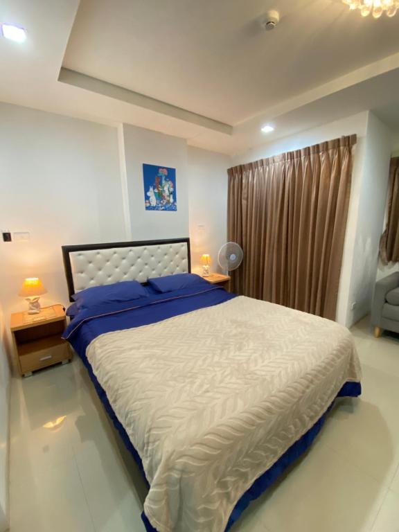 Un dormitorio con una cama grande y una ventana. en Beach 7 Condo, Pattaya, en Jomtien Beach