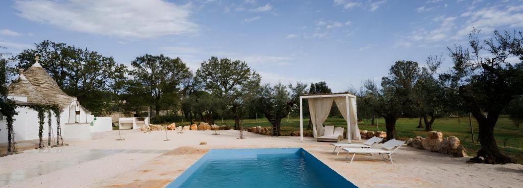 une piscine au milieu d'une arrière-cour dans l'établissement Trullo La Dama Forestiera, à Alberobello