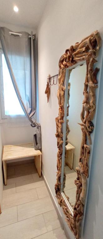 a mirror with a wood frame and a bench in a room at Message in a Bottle Bed and Breakfast in Camporosso