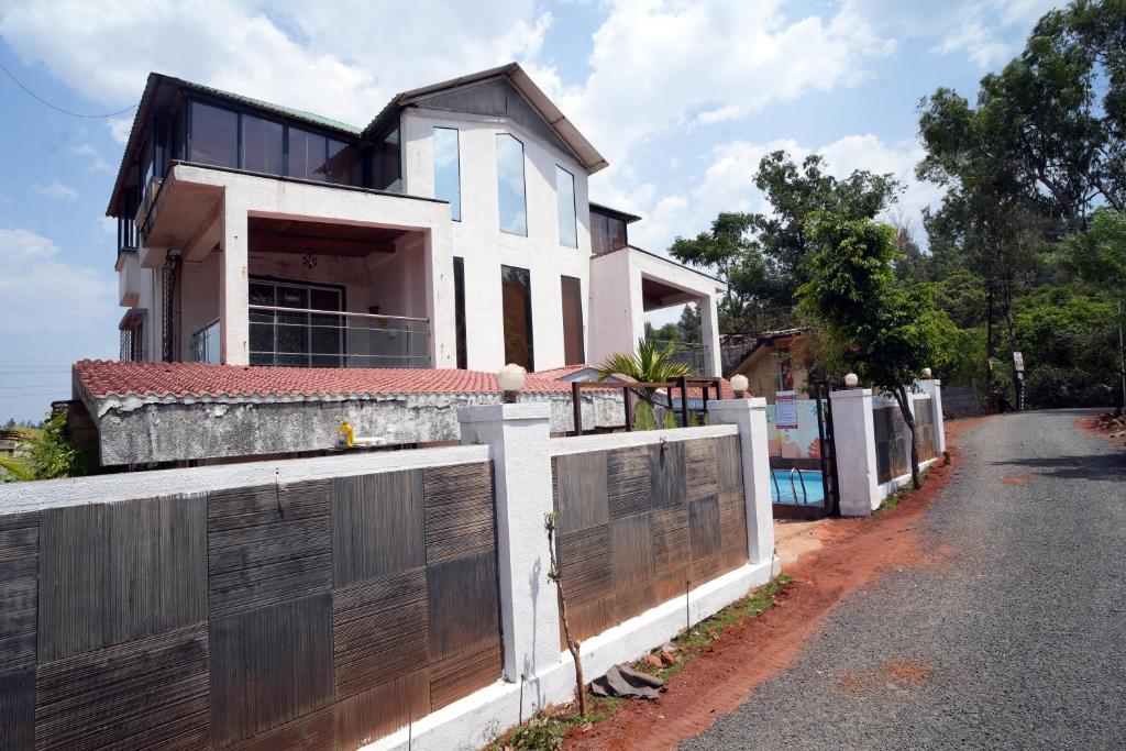 une maison avec une clôture et un portail dans l'établissement Malama Stay The Cloud Villa 4BHK Panchgani, à Mahabaleshwar
