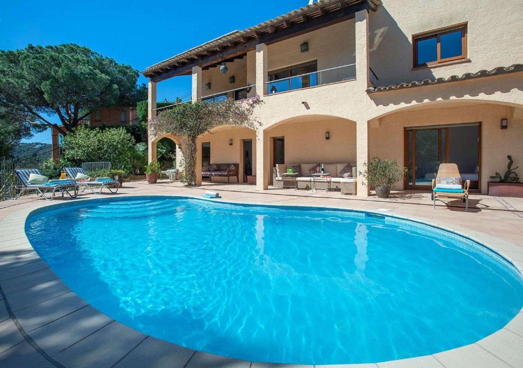 ein großer blauer Swimmingpool vor einem Haus in der Unterkunft Villa Ceylon by Vintage Travel in Tamariu