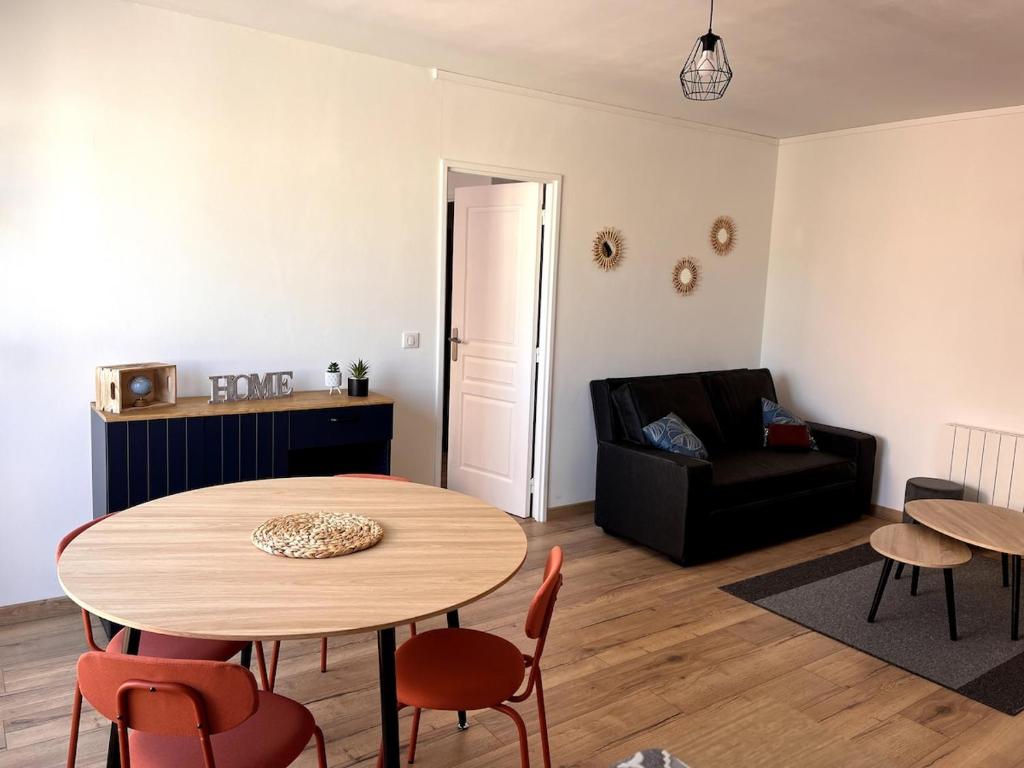 un salon avec une table et un canapé dans l'établissement Bel appartement cosy Chartres, à Chartres