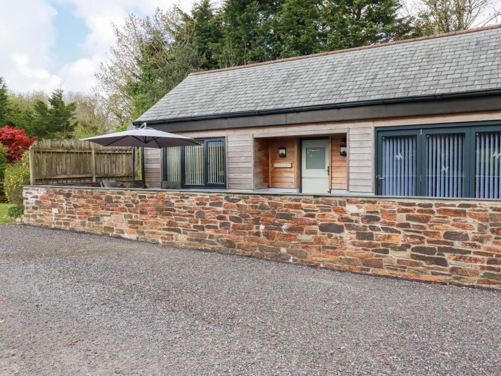 a brick building with an umbrella in front of it at The Stables in Saint Columb Major