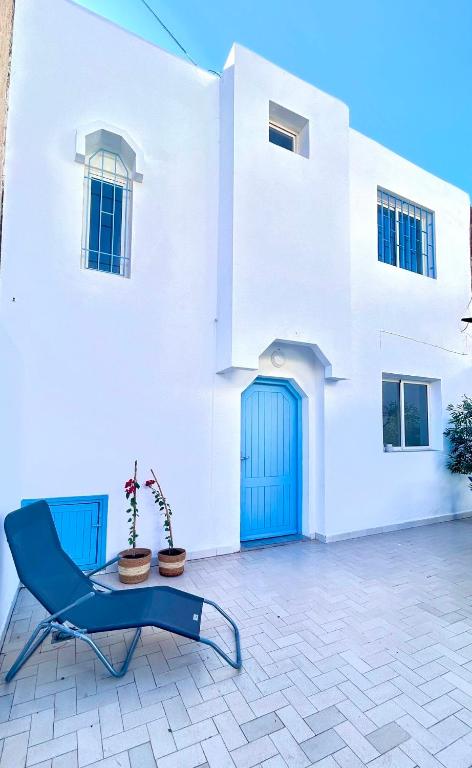 a blue chair sitting in front of a white house at Villa Bleue Agadir climatisée-centre-3chambres in Agadir