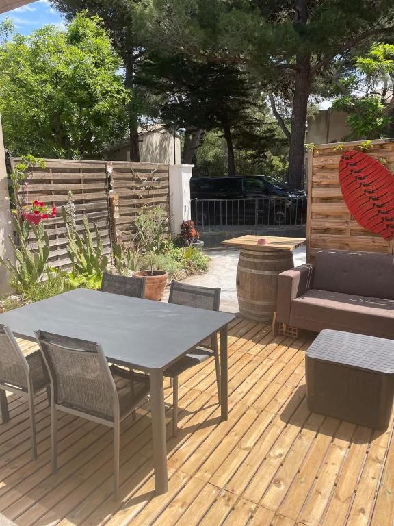 un patio avec une table, des chaises et un canapé dans l'établissement Appartement Villa Lucie, à Leucate