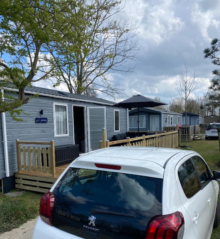 a white car parked in front of a house at Chalet 4 personen HZ 18 in Lauwersoog