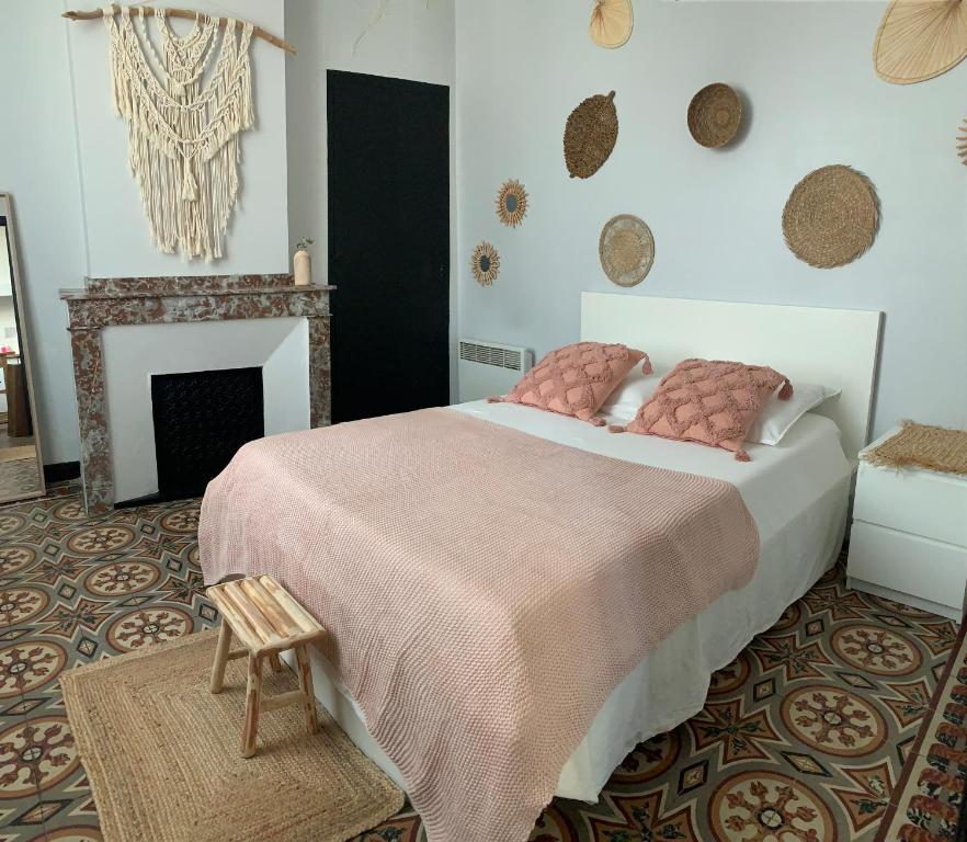 - une chambre avec un grand lit et une cheminée dans l'établissement La maison de la gare, à Carcassonne