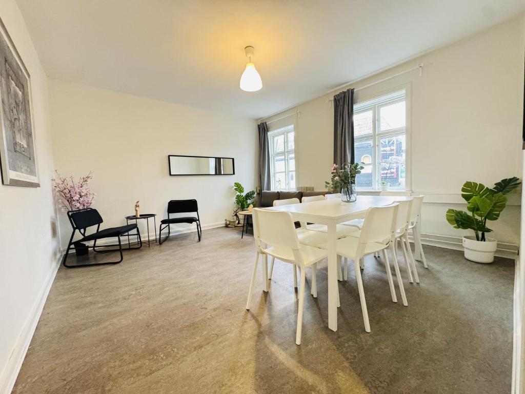 a dining room with a white table and chairs at aday - 8 bedroom Apartment on the Pedestrian Street in Aalborg