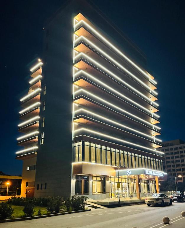 a tall building with a car parked in front of it at Hotel Alexandra in Mamaia