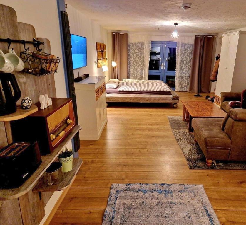 a living room with a couch and a television and a living room at Ferienwohnung Gute Seele in Bad Lauterberg