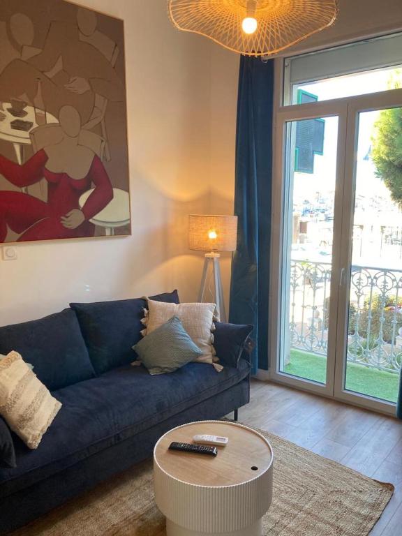 un salon avec un canapé bleu et une table basse dans l'établissement Evasion Marine 3, à Palavas-les-Flots
