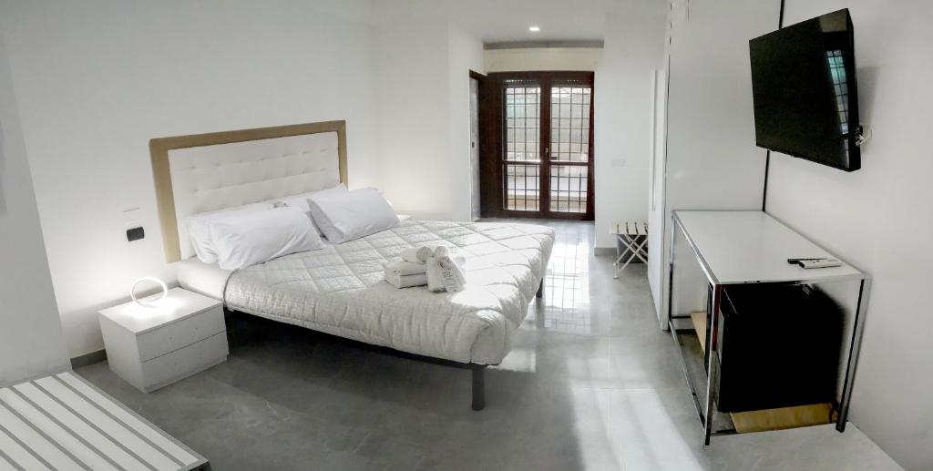 biała sypialnia z łóżkiem i biurkiem w obiekcie La Fiera GuestHouse w mieście Fiumicino