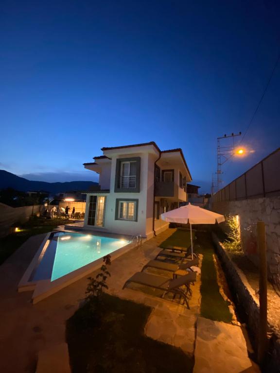 a villa with a swimming pool at night at Villa 77 in Kaş