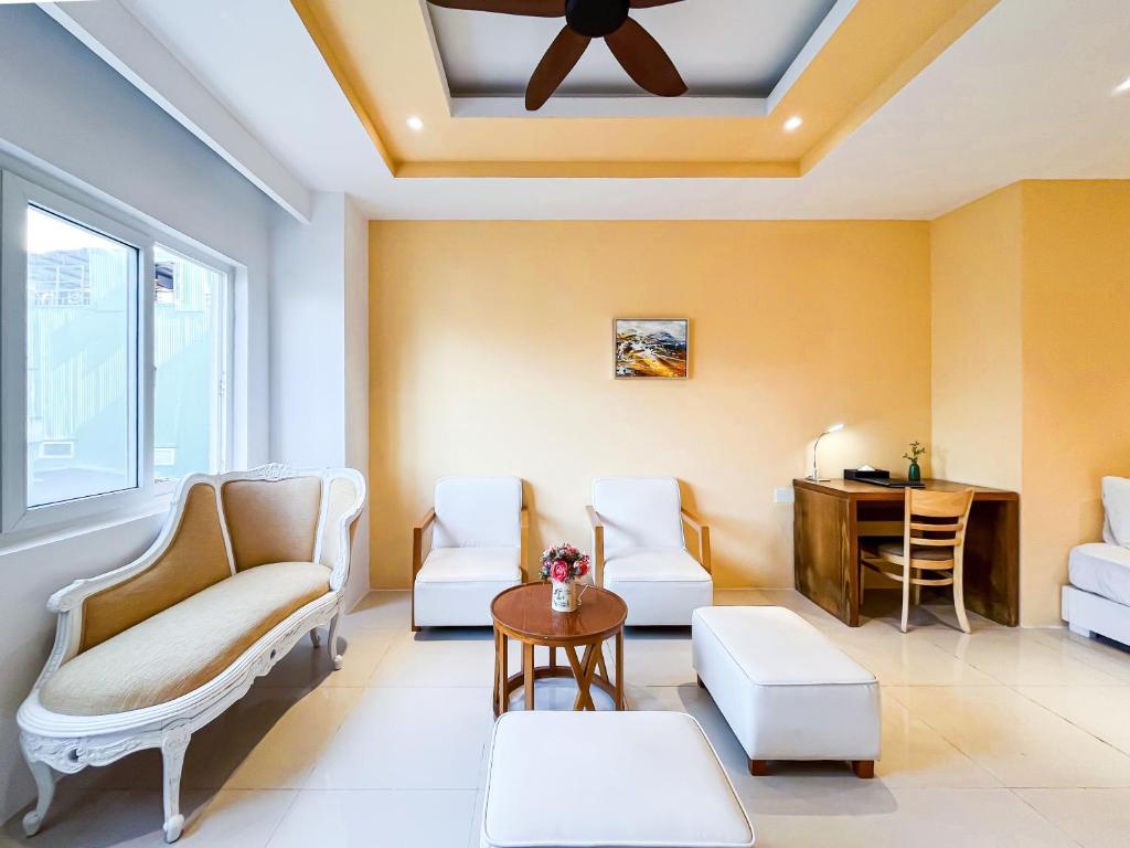 A warm-toned lounge with upholstered seating, a small table and a compact desk.