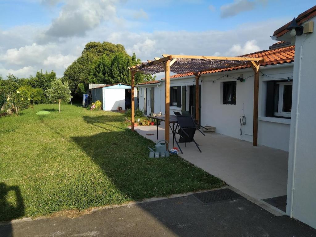 arrière-cour d'une maison avec pergola dans l'établissement Longère familiale charentaise en Charente-Maritime, à La Tremblade