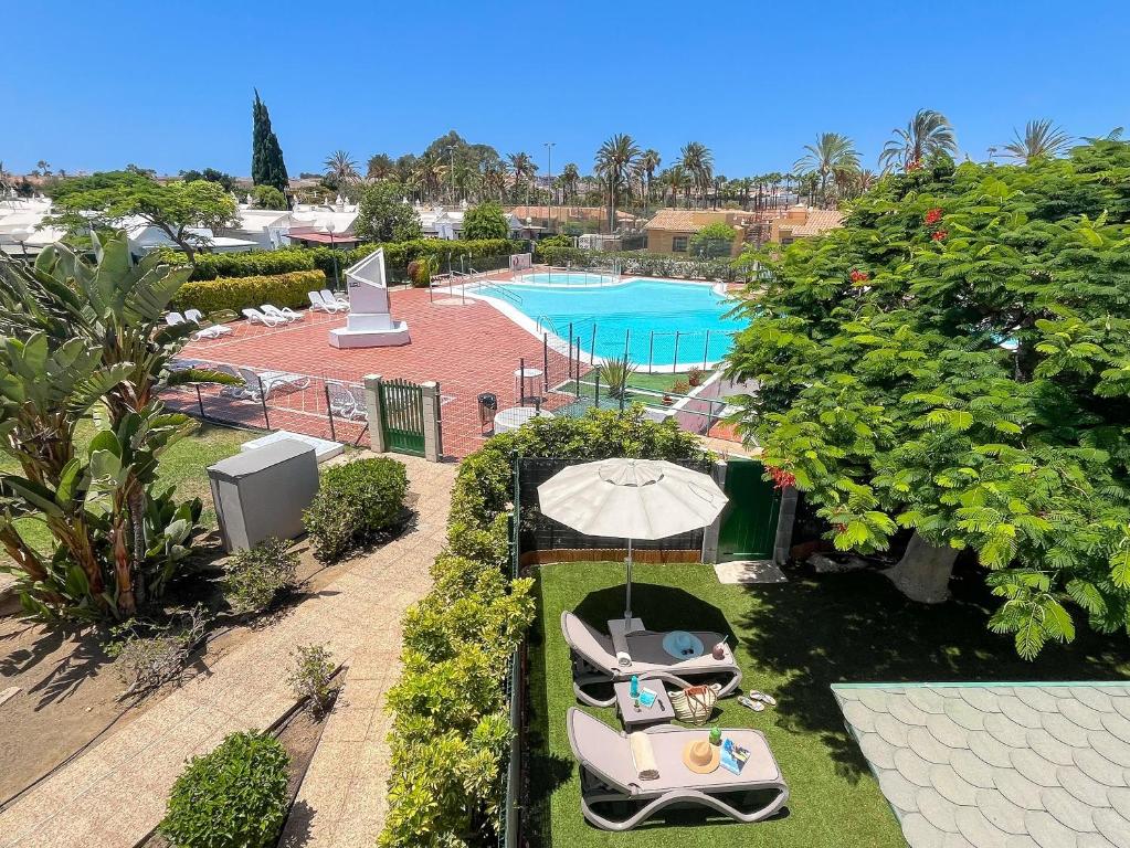 an overhead view of a pool with a table and an umbrella at Bungalow Playa Flor 82 by Villagrancanaria in San Bartolomé de Tirajana