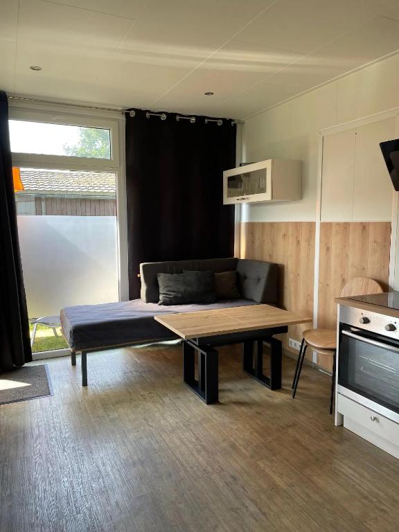 a living room with a couch and a table at Am See I - Lastering Ferienhäuser & Apartments in Wettringen