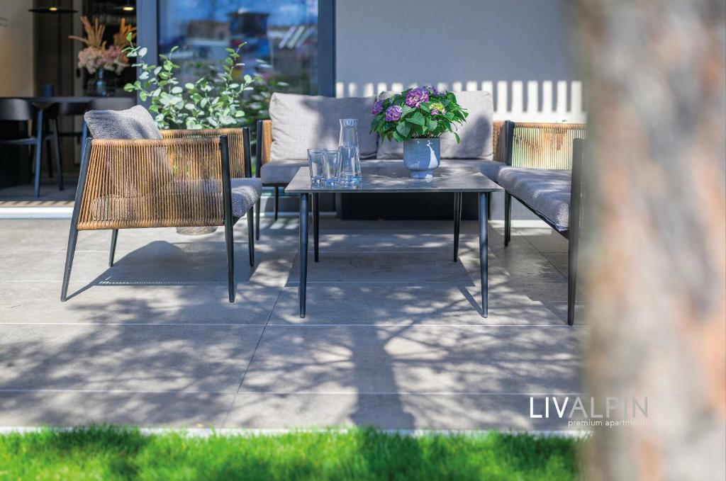 a table and chairs with flowers on a patio at LIVALPIN Comfort in Garmisch-Partenkirchen