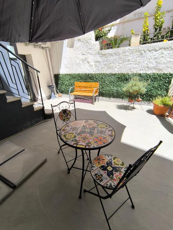 a patio with a table and two chairs and an umbrella at Appartamenti Poseidon in Marsala
