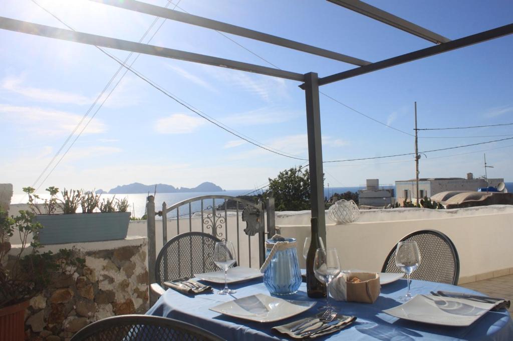 a table with a blue table cloth on a balcony with a view at Le Case dei pescatori - Sirena in Arcipelago Ponziano