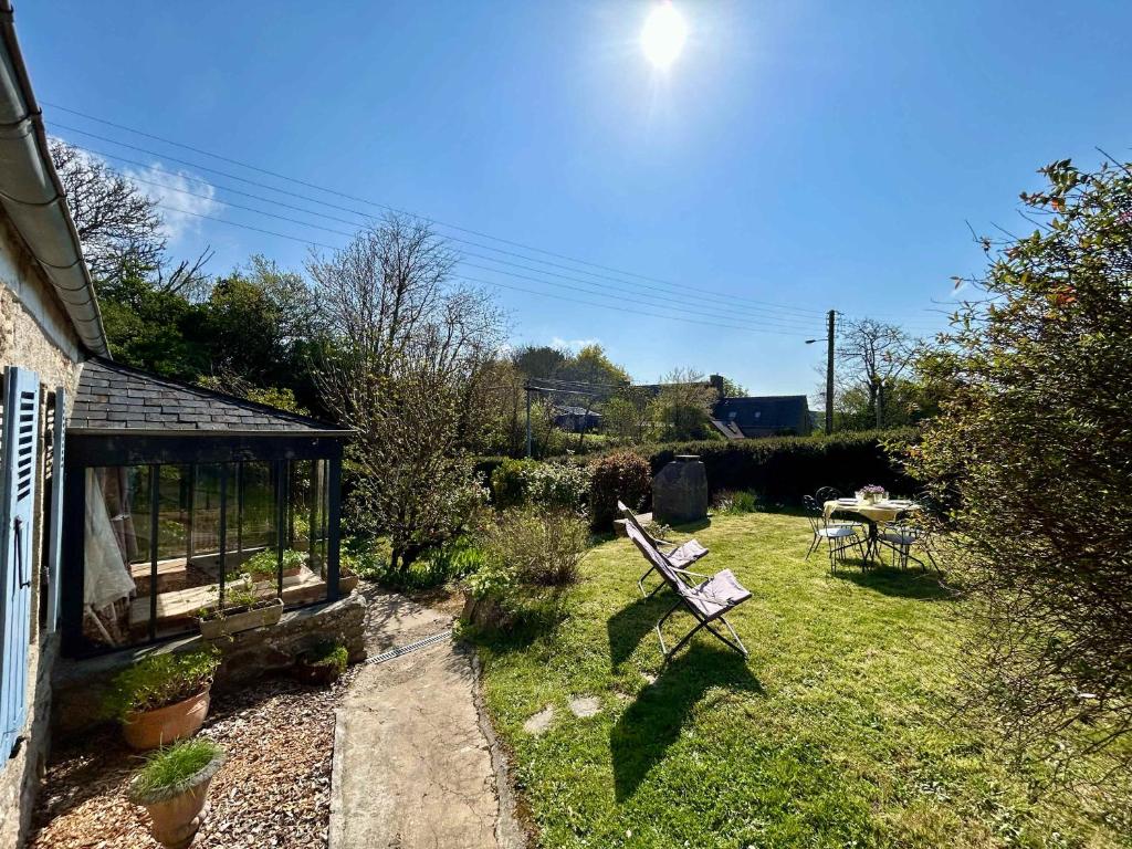 un jardin avec un banc et une table dans la pelouse dans l'établissement Pretty charming Breton cottage for 4 people, à Trédrez