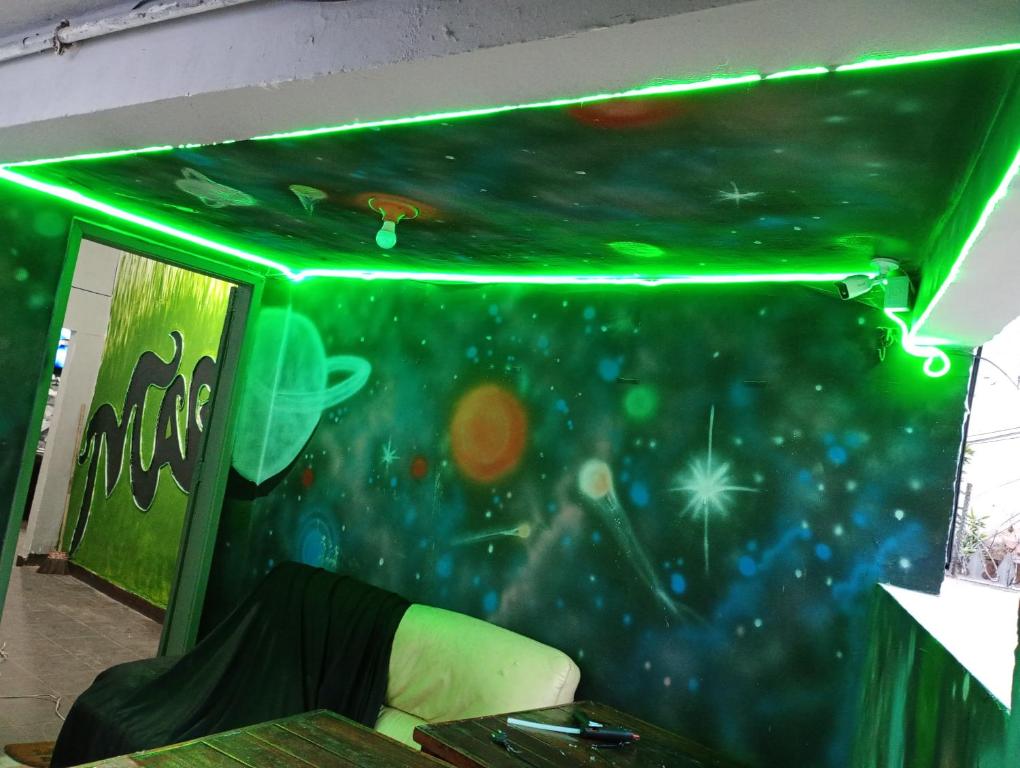 Una habitación con un techo verde con un mural espacial. en O mago hostel, en Río de Janeiro