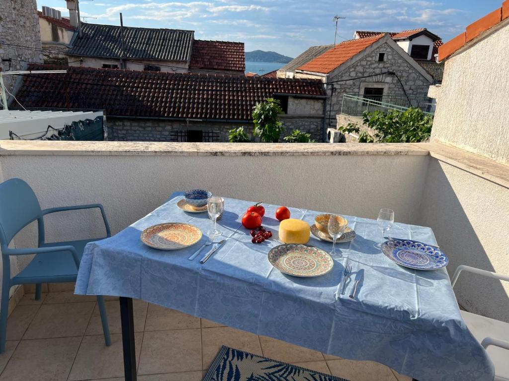 a blue table with plates of food on a balcony at Ferienhaus Insel Murter Vivaldi/Stonehouse Betina in Betina