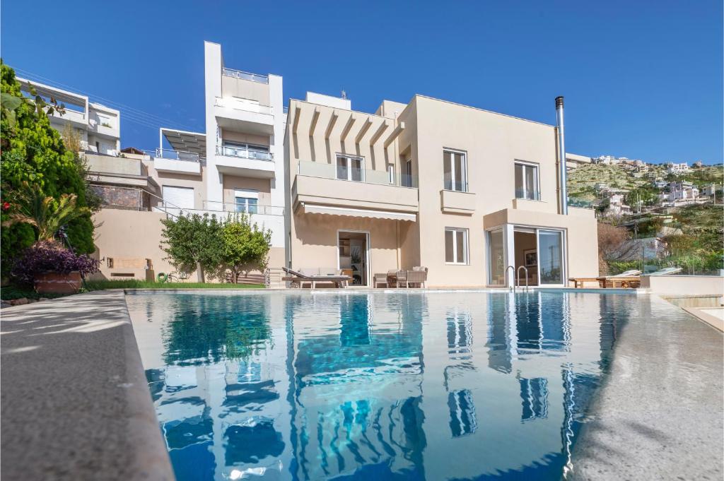 a villa with a swimming pool in front of a building at Serenity Villa by Comfortbnb in Saronida