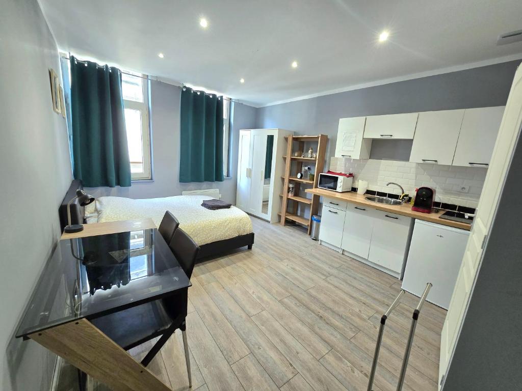 Cette petite chambre comprend un lit et une cuisine. dans l'établissement appartement hypercentre 301 +WIFI+INDEPENDANT+ CUISINE TOILETTE SALLE DE BAIN PRIVATIVE, à Valenciennes