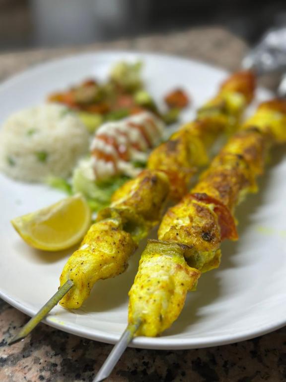 a white plate of food with skewers of food at Hotel L'Initiale in Oualidia