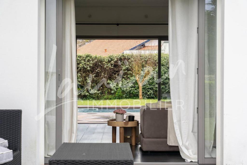 - un salon avec vue sur la piscine dans l'établissement Villa Augusta – Biarritz Phare, à Anglet