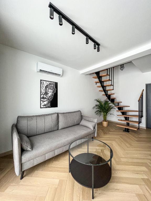 a living room with a couch and a glass table at LOFT Apartments in Piotrowice