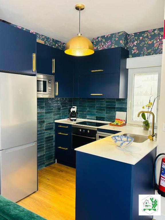 a kitchen with blue cabinets and a white refrigerator at Bilbao La Vieja Arena WIFI in Bilbao