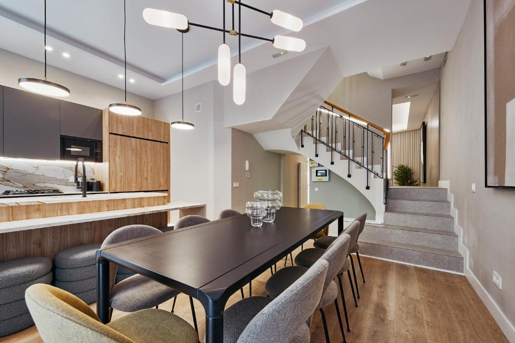 a dining room with a black table and chairs at Fuencarral Living 7BR 7BH in Madrid
