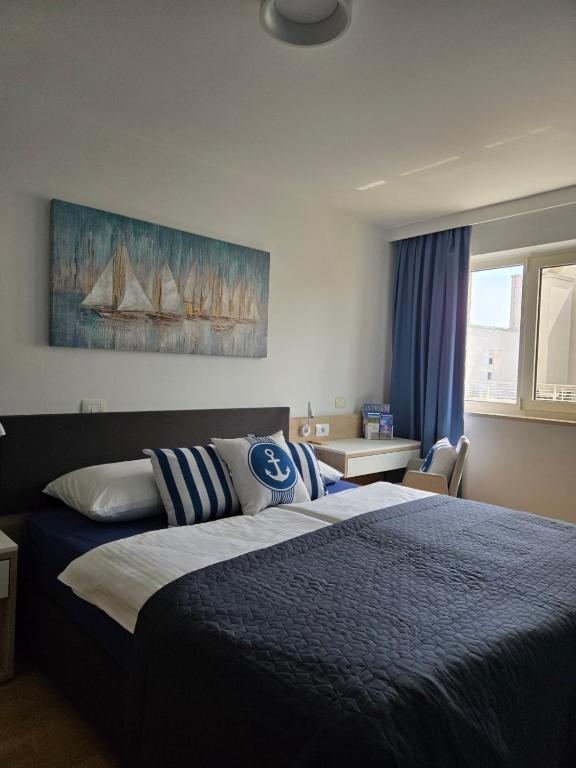 a bedroom with a bed with a blue comforter at Apartment Belaj SeaSide Resort - Sea view in Umag