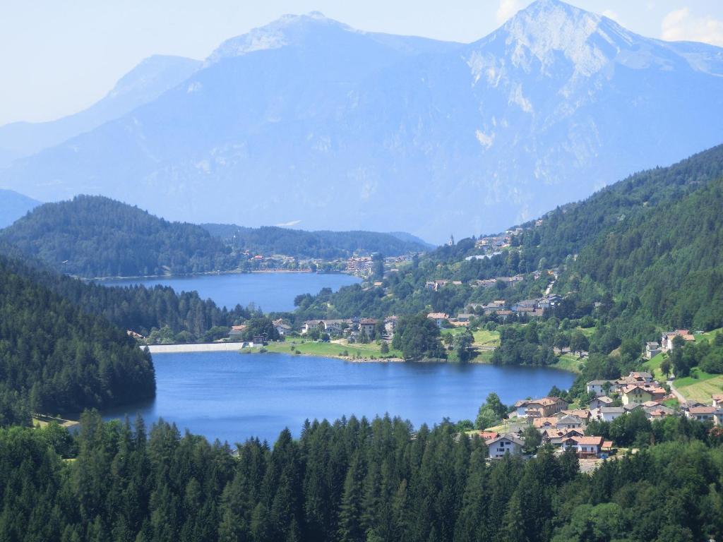 una vista di un lago con le montagne sullo sfondo di Maso La Vecchia Quercia a Baselga di Pinè