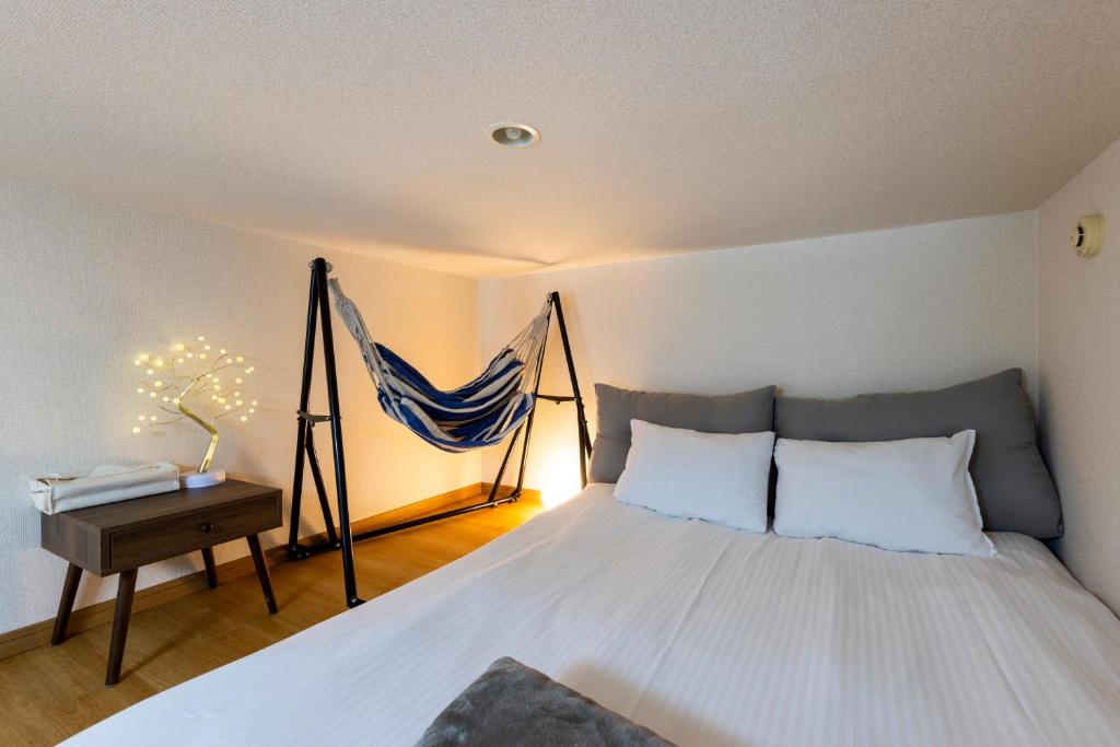 a bedroom with a bed with a hammock above it at Otani gofuku in Fukuoka
